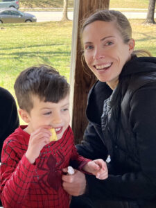 Picture of Elisabeth Chaves and her son, a young boy in a spiderman costume.