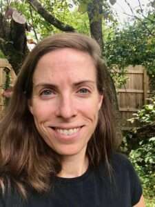 Profile picture of Elisabeth Chaves, a white woman with brown hair and a backyard behind her.