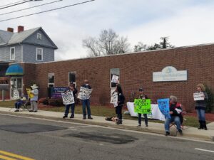 Picture of people holding signs in front of a clinic