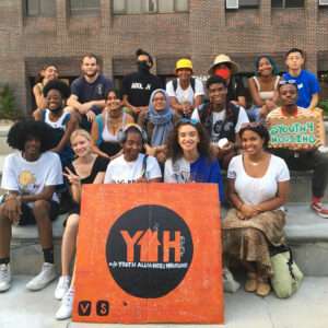 Picture of about 20 young people holding a sign with the YAH logo on it.
